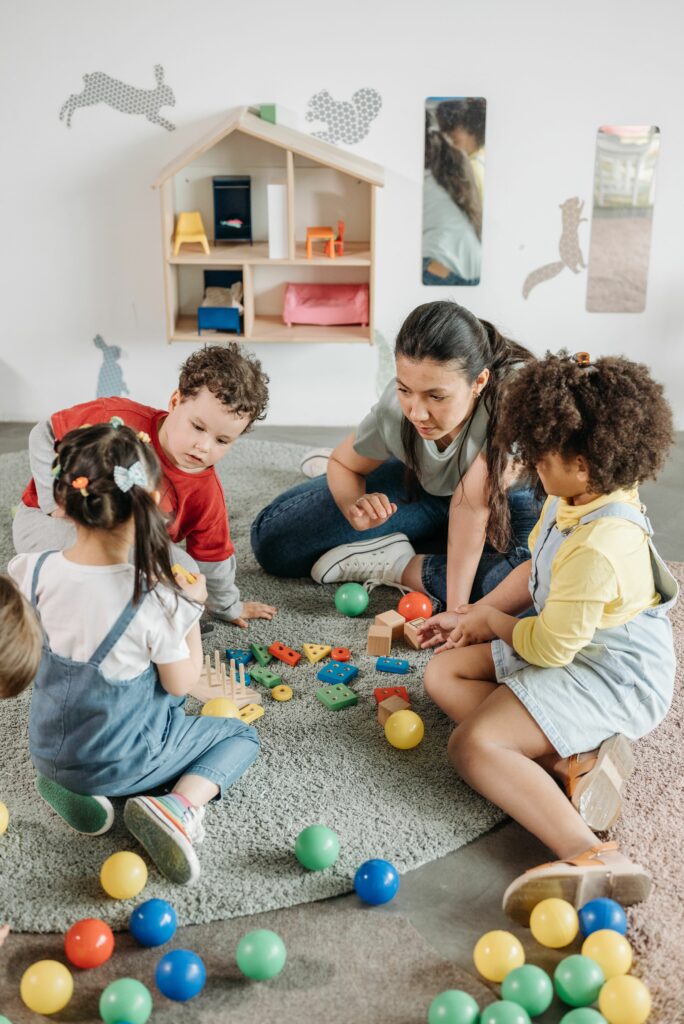 Kids and teacher engaging with toys and activities in a colorful kindergarten.